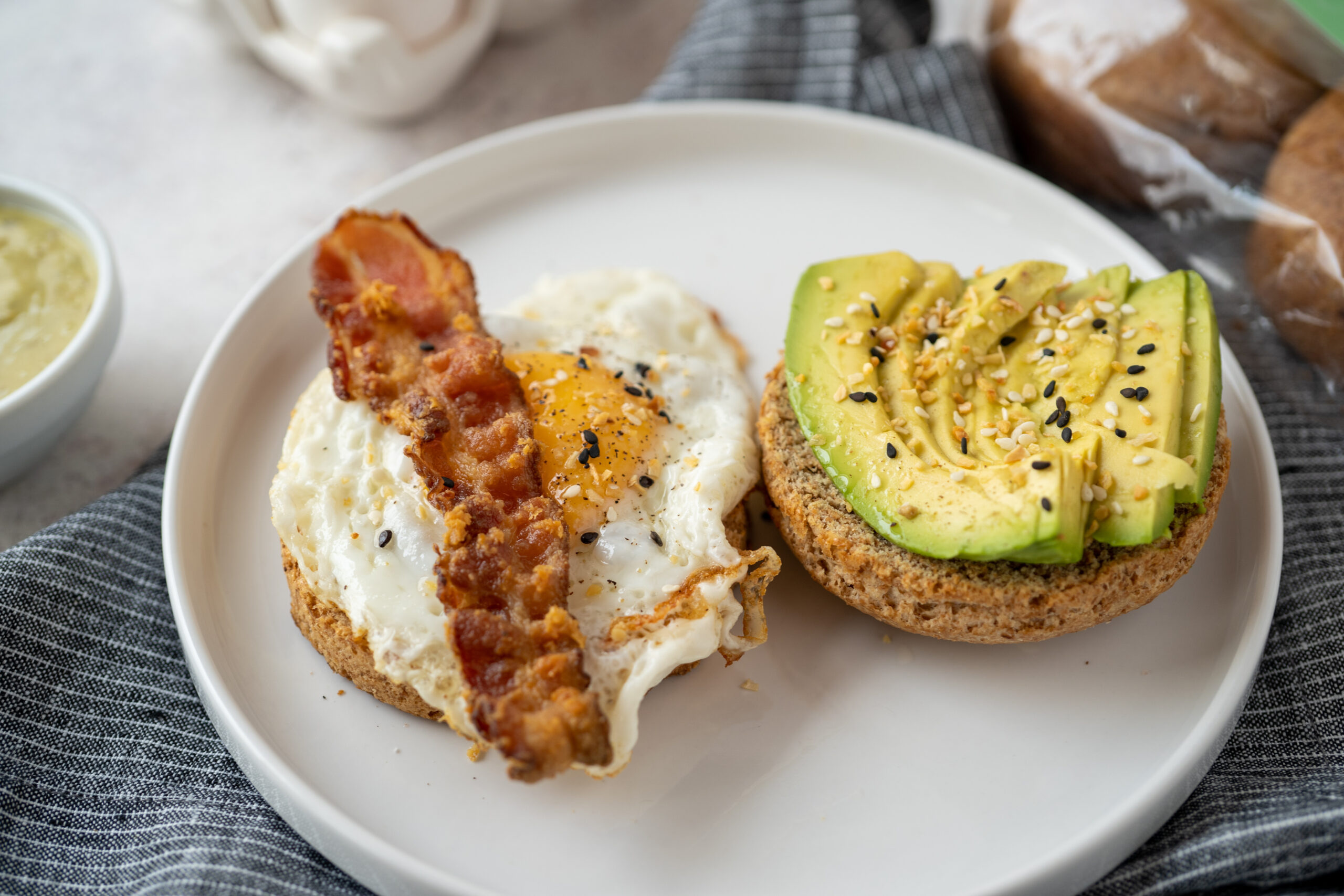 Par de bisquets preparados con huevo, aguacate y tocino, representa un desayuno balanceado